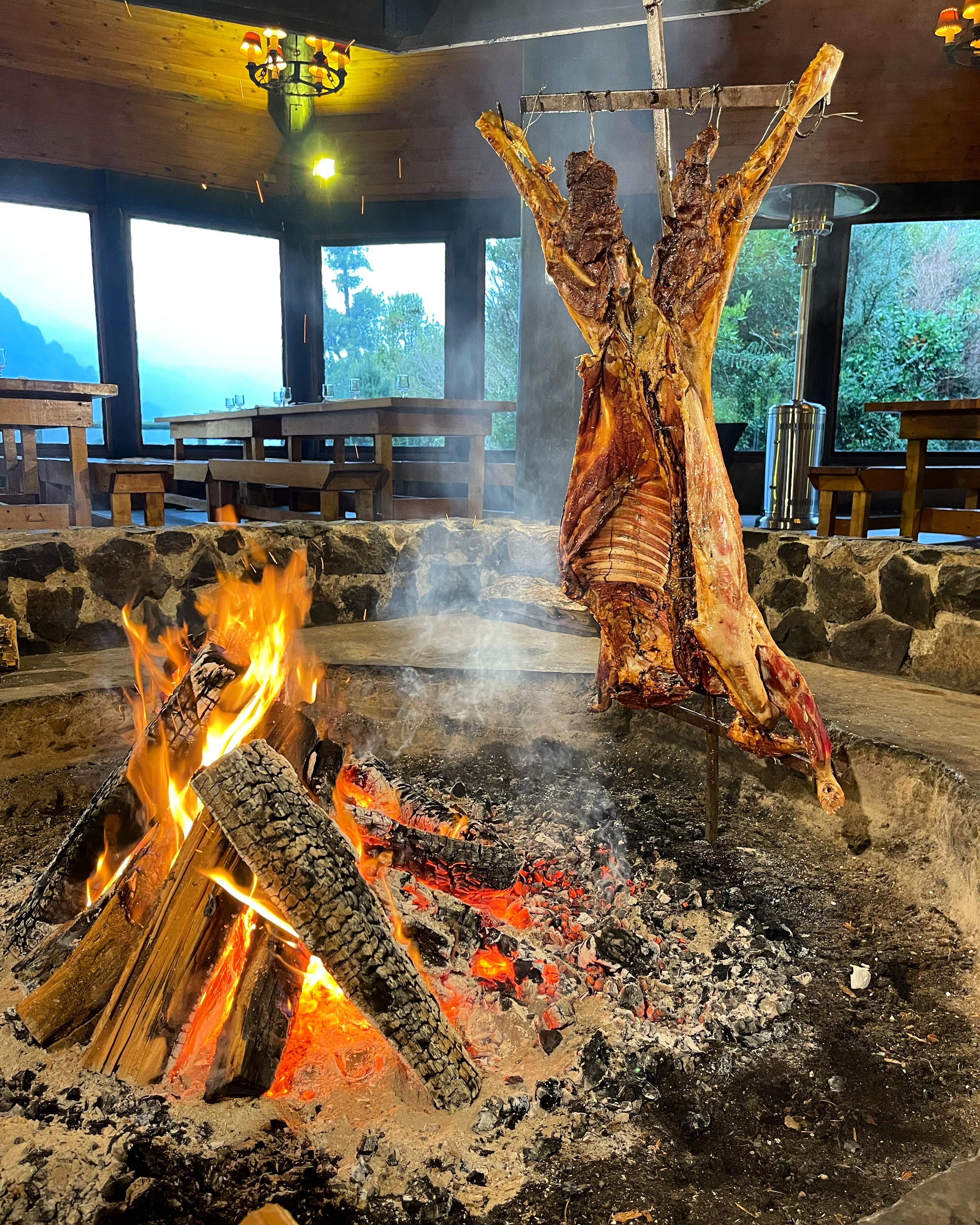 Whole lambs slow-roasting over an open fire at Man Cave Patagonia